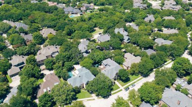 İki katlı, uzun boylu, olgun ağaçlarla çevrili iki katlı evler Coppell 'deki lüks yüzme havuzları Dallas Fort Worth Metroplex, Teksas' ın banliyöleri, antenler. ABD