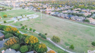 Planlanmış büyük banliyö parkı, Plano, Texas 'ta uzun bisiklet yolu, elektrik direkleri boyunca iki katlı evler, yemyeşil ağaçlar, anten. ABD
