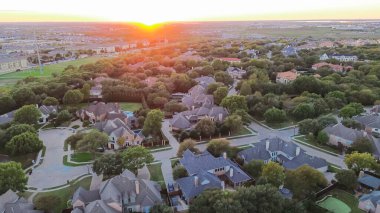 Yeşillik yeşil ağaç, yüzme havuzu, banliyö parkında bisiklet yolu, apartman kompleksi, Plano, Texas, anten çevresindeki lüks malikaneler üzerinde gün batımı. ABD