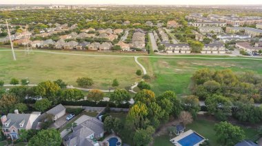 Planlanmış büyük banliyö parkı, Plano, Texas 'ta uzun bisiklet yolu, elektrik direkleri boyunca iki katlı evler, yemyeşil ağaçlar, anten. ABD