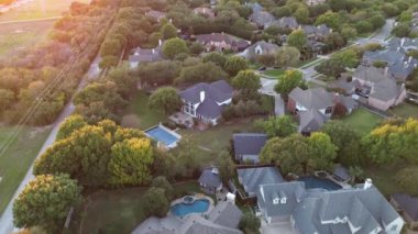 Midway Road, Plano, Texas 'ta uzun bisiklet yolu üzerinde banliyö parkının yakınındaki lüks yerleşim yerlerinde geniş arka bahçeli yüzme havuzlu malikaneler, yemyeşil ağaçlar günbatımı, üstgeçit.