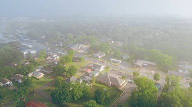 Morning foggy over West Gentry Avenue in downtown Checotah, small town in McIntosh County, Oklahoma, mix of commercial buildings, churches, schools, residential neighborhood, lush green, aerial. USA clipart