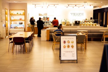 FRISCO, TX, US-NOV 19, 2024: Customers order drinks from Vertue Coffee Roasters inside Capital One Caf , bank-affiliated coffeehouse chain offering hot drinks, free WiFi welcoming space modern setting clipart