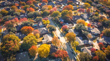 Upscale suburban houses with swimming pools, large fenced backyard, colorful fall foliage autumn leaves in Coppell suburbs Dallas Fort Worth metroplex, fast growing housing market, aerial view. USA clipart