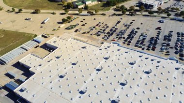 Full parking at entrance of large grocery store with commercial rooftop and packaged units RTU on flat roof, HVAC conditioning cooling, dehumidifying, heating, heat pump and air handlers, aerial. USA clipart