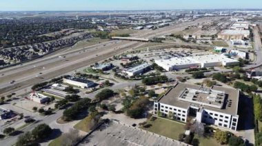 Lyndon B Johnson Interstate I-635 otobanı boyunca yoğun trafik var. Yol kenarı restoranı, ticari bina, ofis alanı, Dallas 'ta yeni bir inşaat konutu, üst geçit.