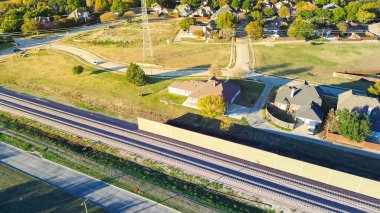 Power pylons in suburban residential area with precast concrete walls noise barriers, sound mitigation light railroad Belt Line Road in Coppell, Texas, absorptive acoustic establish quiet zones. USA clipart