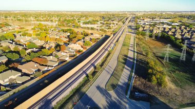 Fast growing mixed-use development area with residential houses, light rail system, precast concrete walls noise barrier along Belt Line Road suburbs Dallas, sound mitigation city quiet zones. USA clipart