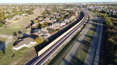 Beton duvarların, ses engellerinin, Coppell 'deki hafif demiryolu kemeri yolunun, Dallas Fort Worth' un varoşlarının, trenlerin tekerlek motor gürültüsünün, üstgeçişin gelişimi devam ediyor.