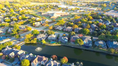 Coppell 'deki MacArthur Bulvarı' ndaki lüks göl yerleşim yerlerindeki banliyö okul bölgesi Dallas, Teksas 'ın banliyöleri, iki katlı büyük banliyö evlerinin üzerine renkli sonbahar yaprakları. ABD