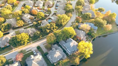 Lakeside residential street row of large upscale suburban houses with swimming pools surrounding by vibrant fall foliage in Coppell, suburbs Dallas, Texas, fast growing real estate housing market. USA clipart