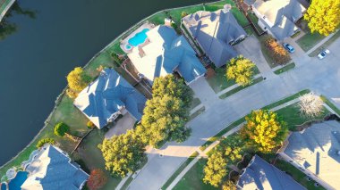 Nightly degree aerial upscale lakeside suburban houses with swimming pools surrounding by vibrant fall foliage in Coppell, suburbs Dallas, Texas, fast growing real estate housing market, aerial. USA clipart