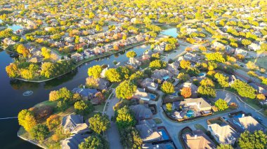 İki katlı rıhtımlı büyük banliyö evleri, yüzme havuzları, Coppell 'deki renkli sonbahar yaprakları, Dallas, Teksas' ın banliyöleri, hızlı büyüyen gayrimenkuller, antenler. ABD