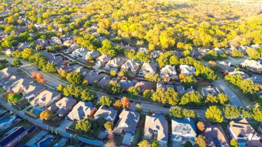 Coppell, Dallas, Teksas 'ın banliyölerinde canlı şehir parkı sakinleri, renkli sonbahar yaprakları, yüzme havuzlu iki katlı evler, büyük bir arka bahçe, anten. ABD