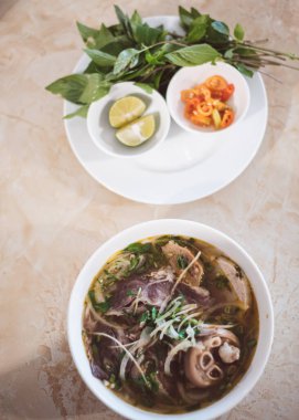 Full set of traditional Bun Bo Hue noodles paired with tender slices of beef, vermicelli round rice noodles, onions, fresh herbs, lemon, peppers, spicy soup with deep layers of flavor in Vietnam. Asia clipart