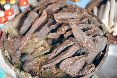 Bambu tüplerinde Com Lam pilavı ve Mai Chau, Hoa Binh, Vietnam 'daki geleneksel etnik insanların restoranında kırmızı sos ile tütsülenmiş baharatlı bufalo eti yığını kurutulmuş ahşap ateş. Asya