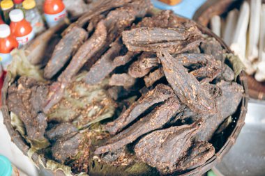 Pile of spiced buffalo jerky snack smoked with Com Lam rice in bamboo tubes and red sauce at traditional restaurant of ethnic people in Mai Chau, Hoa Binh, Vietnam, dried barbeque wooden fire. Asia clipart