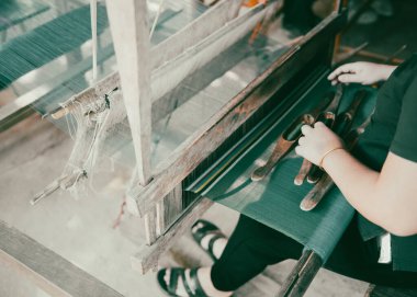 Mai Chau, Hoa Binh, Vietnam 'daki Stilt House' da yetenekli Tayland 'lı kadın brokar dokuma zanaatı. Geleneksel düz mekik tutucusu dokuma tezgahıyla dokuma ipliği taşıyor. Asya