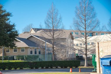 Üniversite binalarının yakınındaki çöp kutusunu ve çok katlı üniversite apartmanlarını geri dönüşümlü hale getirin. Dallas, Teksas 'ta güneşli kış mavi gökyüzü, kampüs yurdunda konaklama yurdu eğitim salonu mezunu. ABD