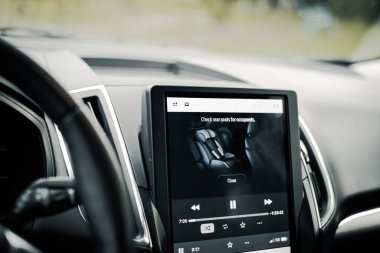 Arka koltukta, park edilmiş modern SUV aracının 12 inçlik LCD dokunmatik ekranının arka koltuğunu kontrol et, sistem uyarısı sürücüsü çıkmadan önce arka koltukları kontrol et, çocukları ve evcil hayvanı başıboş bırakmayı engelle. ABD