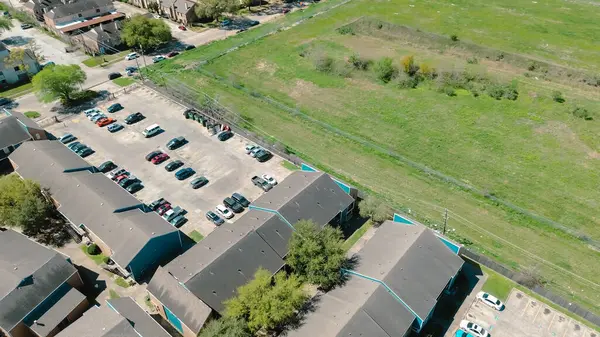 Havadan bakıldığında büyük boş arazi, apartman kompleksi binaları, üstü açık otoparklar, yüzme havuzları, hızlı büyüyen Corporate Drive 'da geliştirilmemiş konum, Çevre Yolu 8, Houston. ABD