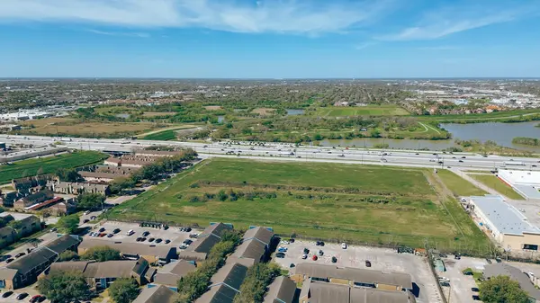 Meşgul Sam Houston Parkway, geniş boş arazisi, göl kenar mahallesi parkı çok katlı apartman kompleksi, kasaba evleri, tek aile evleri. ABD