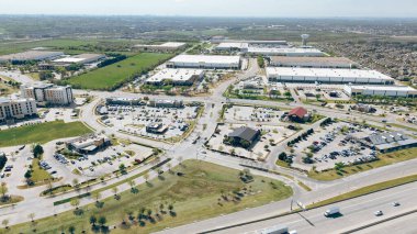 Endüstriyel park, depo binaları, konutlar, alışveriş yerleri Sam Rayburn Tollway yakınlarındaki restoranlar State Highway 121 in The Colony, Denton, Texas, aerial. ABD