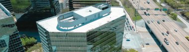 Modern cam ofis binalarının panorama hava manzaralı çatısı, WestChase iş bölgesindeki şirket karargahı, meşgul Sam Houston Tollway ve Richmond Bulvarı kavşağı, karışık kullanım alanı. ABD