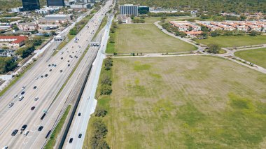 Hızlı büyüyen Westchase iş bölgesinde kalabalık Sam Houston Tollway boyunca boş arazisi olan bir apartman kompleksi. Ofis binaları, cam gökdelenler, oteller, Batı Houston, antenler. ABD