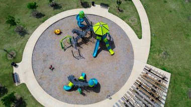 Modern yuvarlak çocuk oyun parkı tırmanma yapıları, slaytlar, bahar binicileri Princeton 'da ahşap pergola Dallas Metroplex' de büyüyen küçük bir kasaba, Kuzey Teksas 'ta Collin County, anten. ABD
