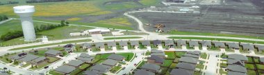 Yeni evindeki panorama hava manzaralı Princeton su kulesi büyük inşaat alanı temel hazırlığı güneş enerjisiyle büyüyen Dallas banliyöleri olan iki katlı büyük banliyö evleri. ABD