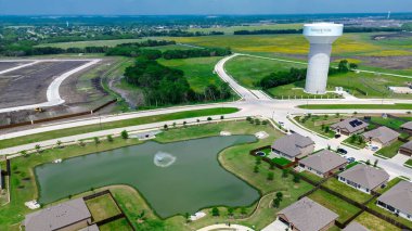 Lakeside 'da çeşmeli iki katlı evler Princeton, Texas' ta Myrick Lane boyunca su kulesi döşeme tesisi hazırlama, yeni inşa edilen büyük evlerin terası, antenler. ABD