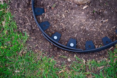 Yakından galvanize edilmiş çivi, geri dönüşümsüz siyah plastik peyzaj kenarlarını delip hortumu korumak için halka etrafında dar bir çember oluşturur, ahşap parçacıkları yatak malzemeleri meyve ağacı bakımını korur. ABD