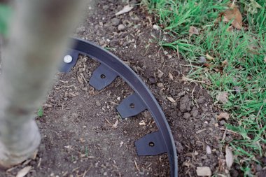 Yakından galvanize edilmiş çivi, geri dönüşümsüz siyah plastik peyzaj kenarlarını delip hortumu korumak için halka etrafında dar bir çember oluşturur, ahşap parçacıkları yatak malzemeleri meyve ağacı bakımını korur. ABD