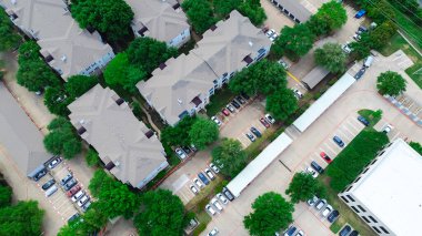 Kuzey Dallas, Teksas 'taki modern apartman kompleksindeki kapalı otopark ve bağımsız garaj, yemyeşil ağaçlarla çevrili kalabalık çok katlı kiralama birimleri, DFW Metroplex' te hızla büyüyen alan. ABD