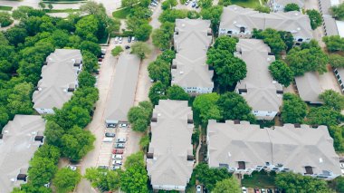 Kuzey Dallas, Teksas 'taki modern apartman kompleksindeki kapalı otopark ve bağımsız garaj, yemyeşil ağaçlarla çevrili kalabalık çok katlı kiralama birimleri, DFW Metroplex' te hızla büyüyen alan. ABD