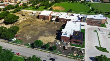 Site hazırlığı, asfalt döşeme, ilkokul yenileme sınıfı inşaatında fırtına drenaj sistemi kurulumu Kuzey Dallas 'taki Marcus Park yakınlarında ağır makineler çalışıyor. ABD