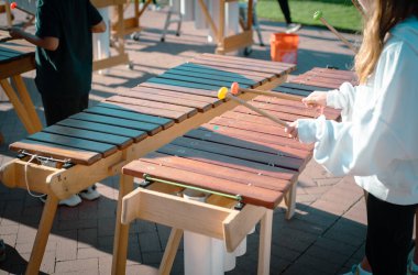 Marimba tokmağı oynayan ilkokul öğrencileri Coppell, Texas 'taki halk parkında ahşap döşeme tahtalarında, PVC borularda, orkestralarda müzik performansı sergilediler. ABD