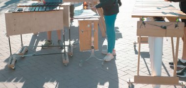 Panorama manzaralı ilkokul öğrencileri Coppell, Texas 'taki halk parkında marimbas tokmağı oynuyorlar. Tahta döşeme tahtalarında, PVC borularda ve orkestralarda yapılan enstrümanlarda açık hava müzik performansı. ABD