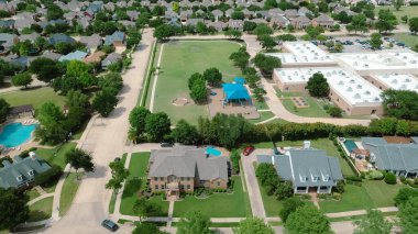 Çimenli tarlası olan ilkokul, Carrollton 'da lüks bir mahallede gölgeli oyun alanı Dallas Fort Worth Metroplex' in banliyöleri, ekstra büyük arazi arka bahçesinde iki katlı pahalı malikane. ABD