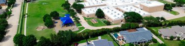 Panorama hava manzaralı ilkokul çimenliği, Carrollton 'ın lüks mahallesindeki oyun parkı Dallas Fort Worth Metroplex' in banliyöleri, iki katlı pahalı bir malikane. ABD