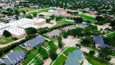 Çimenli tarlası olan ilkokul, Carrollton 'da lüks bir mahallede gölgeli oyun alanı Dallas Fort Worth Metroplex' in banliyöleri, ekstra büyük arazi arka bahçesinde iki katlı pahalı malikane. ABD