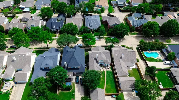 Carrollton 'da, Dallas Fort Worth Metroplex' in banliyölerinde yüzme havuzları olan iki katlı pahalı malikanelerin büyük arka bahçesi, yemyeşil ağaçlarla kaplı yerleşim yerleri, anten. ABD