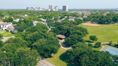 Yürüme yolu, tenis kortları, Preston Hollow 'daki oyuncularla beyzbol sahaları, şehir merkezindeki yüksek binalar arka plan, Dallas Metroplex banliyösü, pahalı malikane, lüks bir bölge. ABD