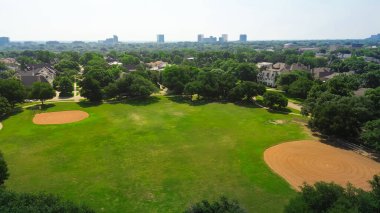 Dallas 'ın göbeğindeki şehir merkezindeki banliyö parkındaki beyzbol sahaları, yemyeşil lüks konutlar lüks konaklama evleri Preston Hollow' un olgun peyzajını kurdu, Teksas. ABD