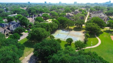 Dallas 'ın başkenti Teksas' ın başkenti Preston Hollow 'da lüks konaklama konutlarının zengin yeşil şehir parkındaki oyuncularla tenis kortları. ABD