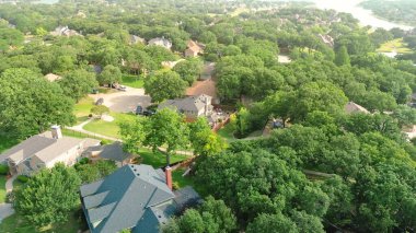 Lewisville Gölü 'nün batısındaki Lake Mahallesi' nde ağaç sıralı sokağın batısında zengin, kalabalık malikane evleri, yüzme havuzu Denton County 'deki Highland Village' da olgun manzaralar. ABD