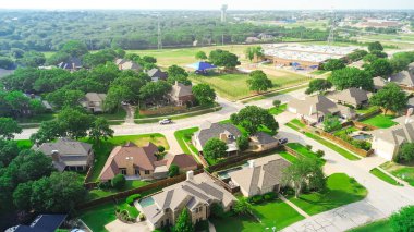 İki katlı lüks banliyö evleri Briarhill Bulvarı boyunca yüzme havuzları, Highland Village ilkokulu bölgesi gölgeli oyun alanı, park yolu, su kulesi, şanzıman hatları, Texas. ABD
