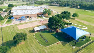 Gölgeli oyun alanı suni çim, pavyon, Dallas Fort Worth metroplex, Teksas yakınlarındaki Highland Village 'da ilkokul kampüsünde salıncaklar, lüks yerleşim bölgesi okul bölgesi. ABD