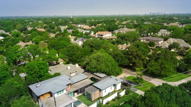 Dallas merkezli iki katlı lüks malikanelerin metal ve kiremitli çatıları var. Arka plan Dallas merkezli, Preston Hollow 'un zengin mahallelerinde yemyeşil ağaçlar, olgun manzaralar. ABD